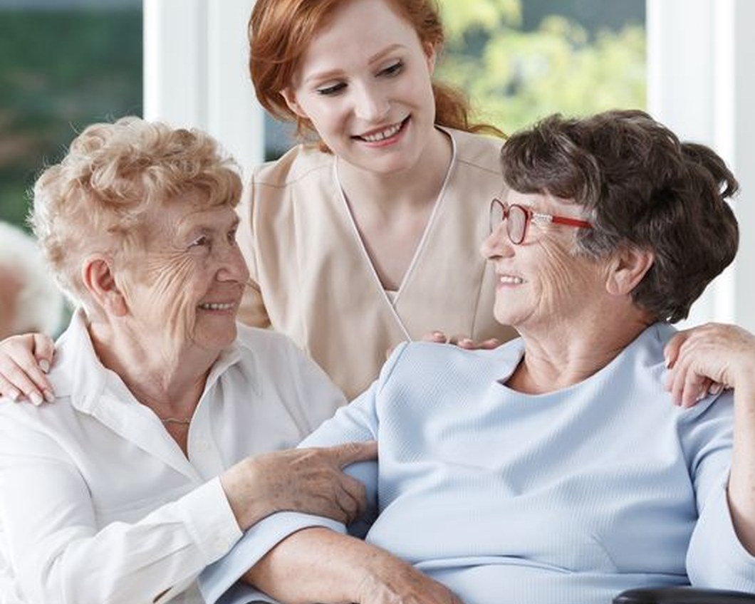 Eine Pflegerin der Diakonie im Gespräch mit zwei Seniorinnen